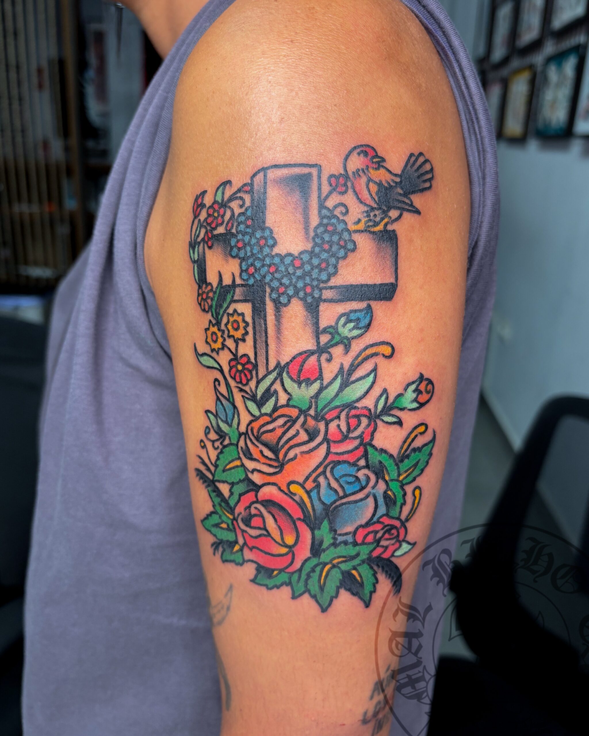 Tatuaje cruz con flores tradicional realizado en Granada. Reserva tu cita en Mal Bicho Tattoo.