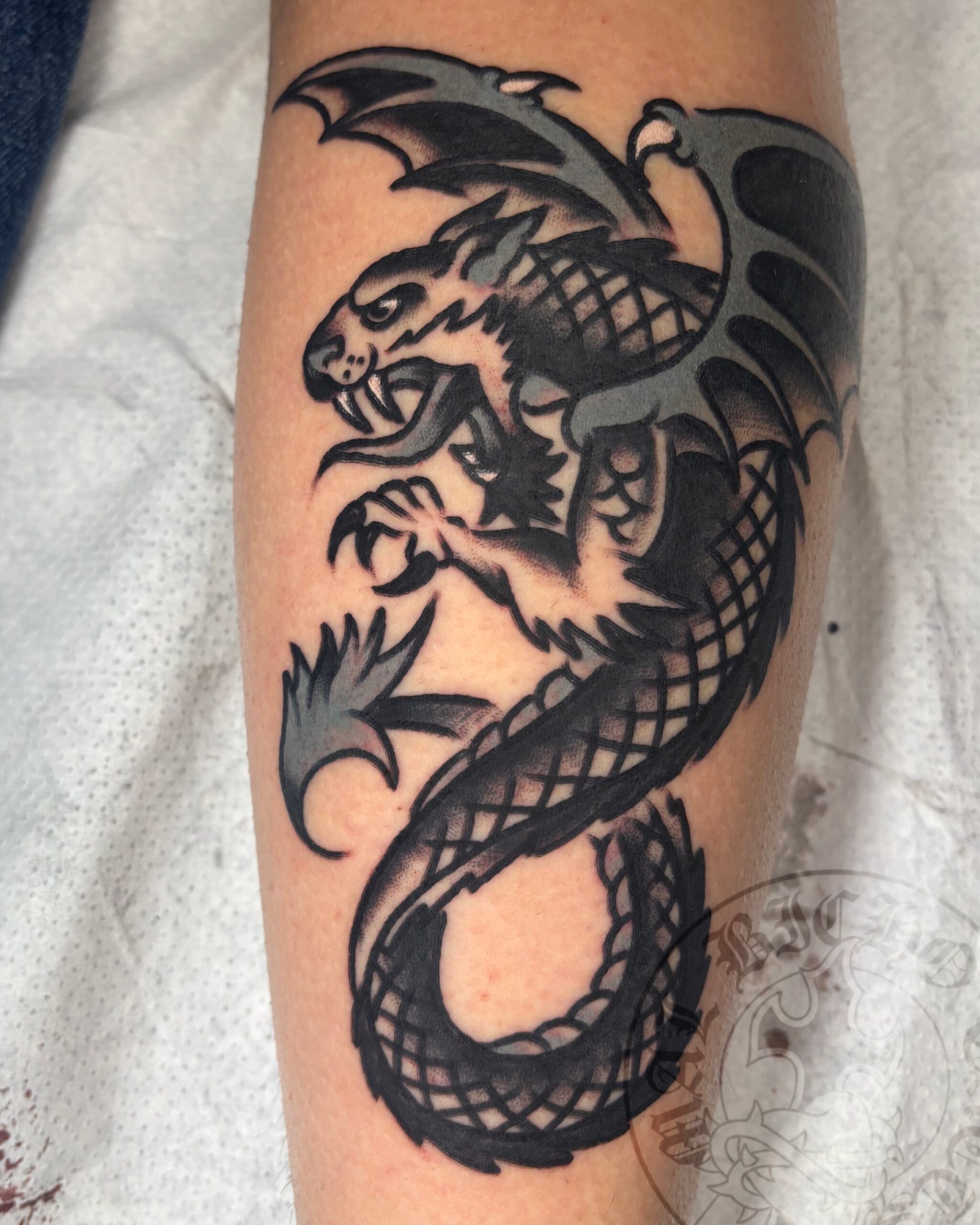 Tatuaje dragón tradicional realizado en Granada. Reserva tu cita en Mal Bicho Tattoo.