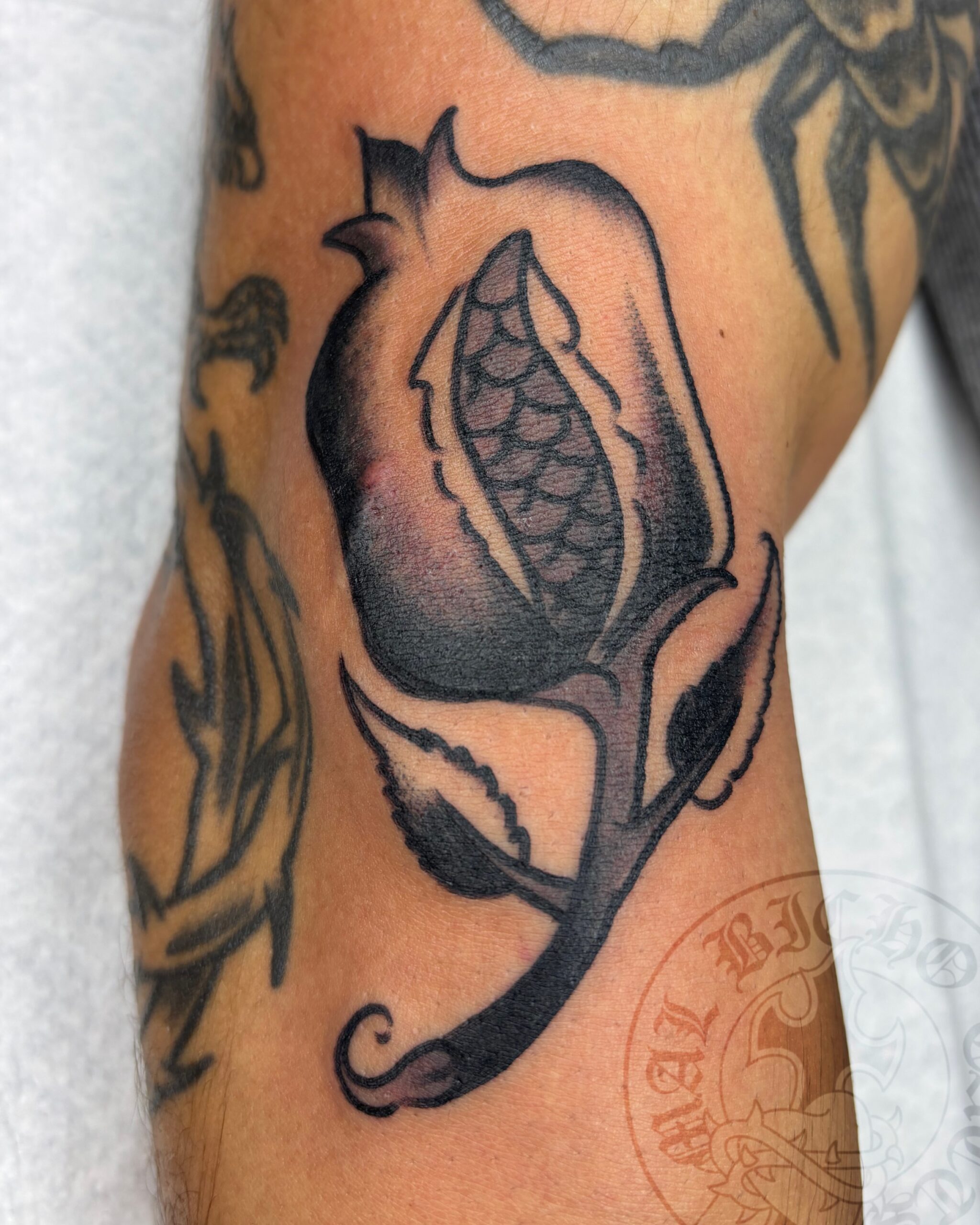 Tatuaje granada tradicional realizado en Granada. Reserva tu cita en Mal Bicho Tattoo.